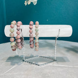 Natural Clear Quartz crystal bracelet holder with multi-colored beaded bracelets on display