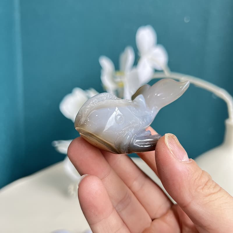 Side view of white agate crystal dolphin showing natural stone patterns