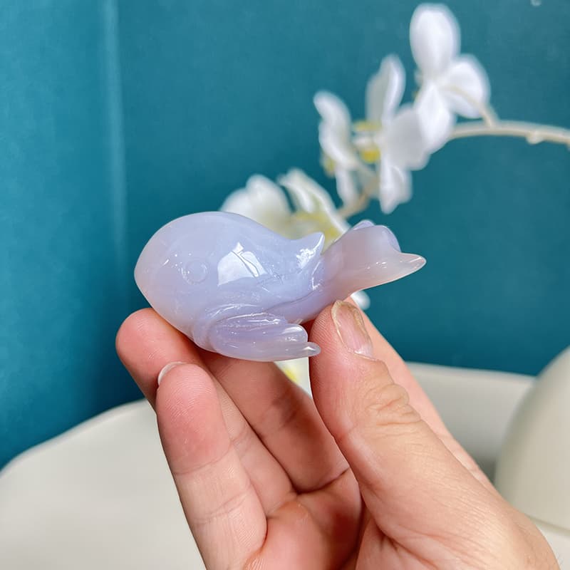 Profile view of handcrafted agate crystal dolphin showing translucent properties