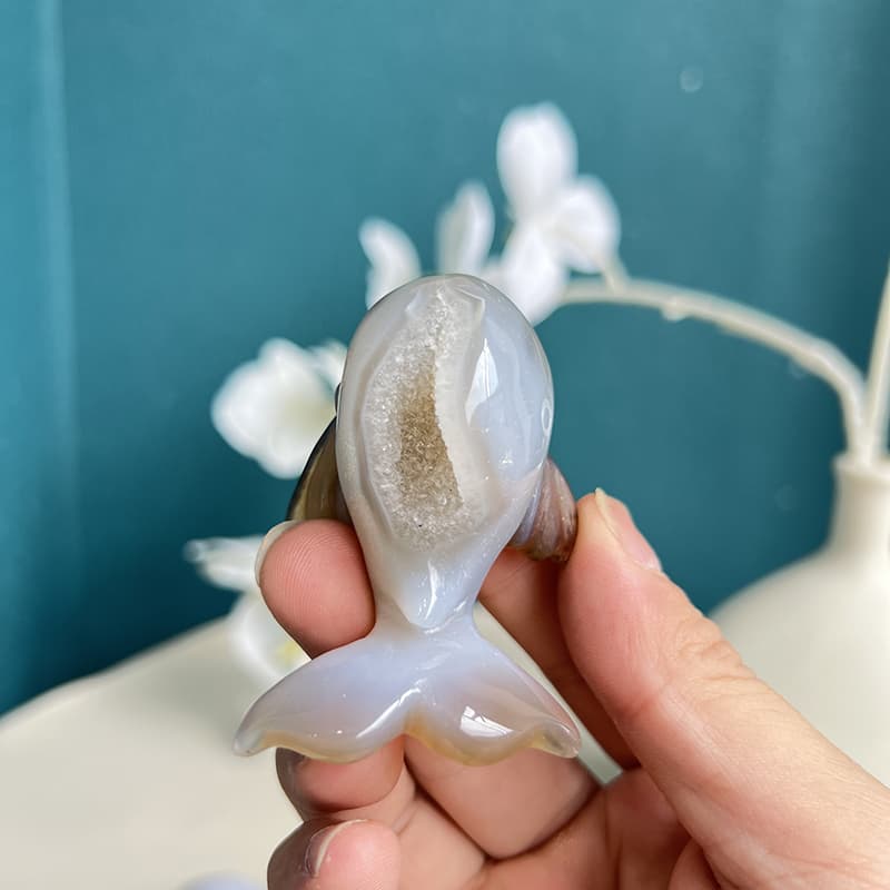 White agate dolphin crystal carving positioned for optimal energy flow