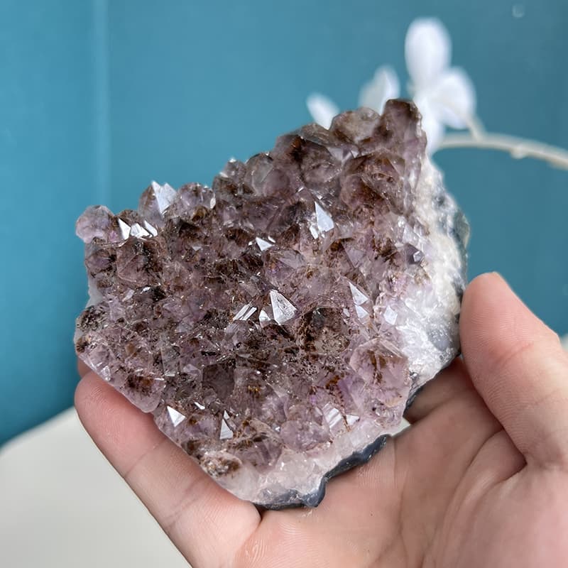 Side view of natural amethyst crystal cluster with deep purple points