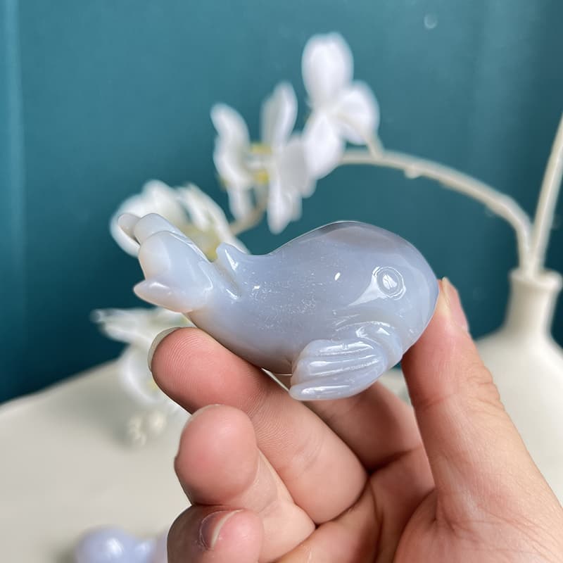 Blue agate whale crystal carving displaying translucency in light