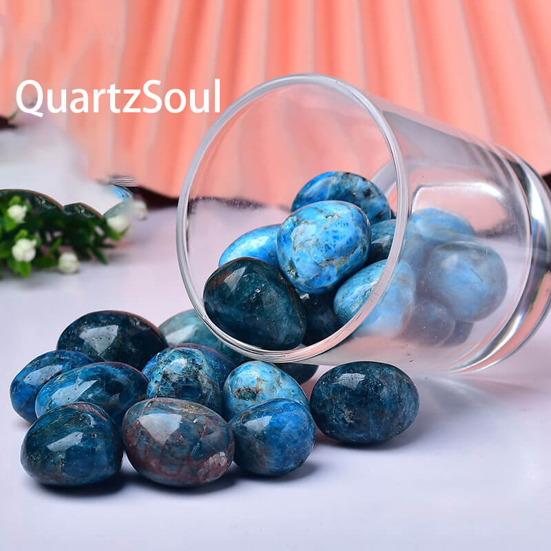 Natural Blue Apatite tumbled gemstones spilling from glass jar, 2-4cm healing crystals