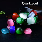 Colorful cat's eye tumbled gemstones displayed in decorative bowl showing chatoyancy