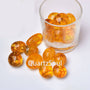 Natural Citrine tumbled stones in glass container, golden prosperity crystals