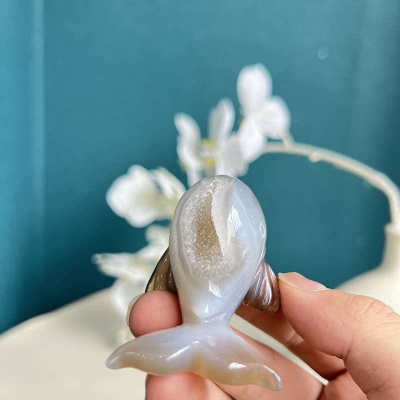 White agate crystal dolphin showing translucent properties with light reflection