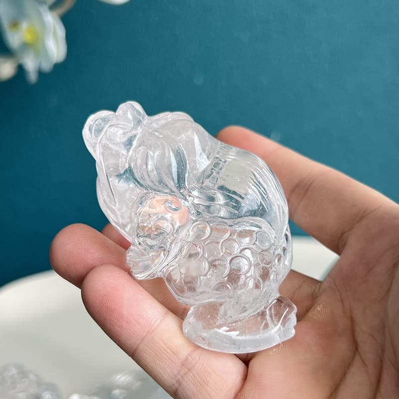Clear quartz golden toad crystal carving displayed on home altar