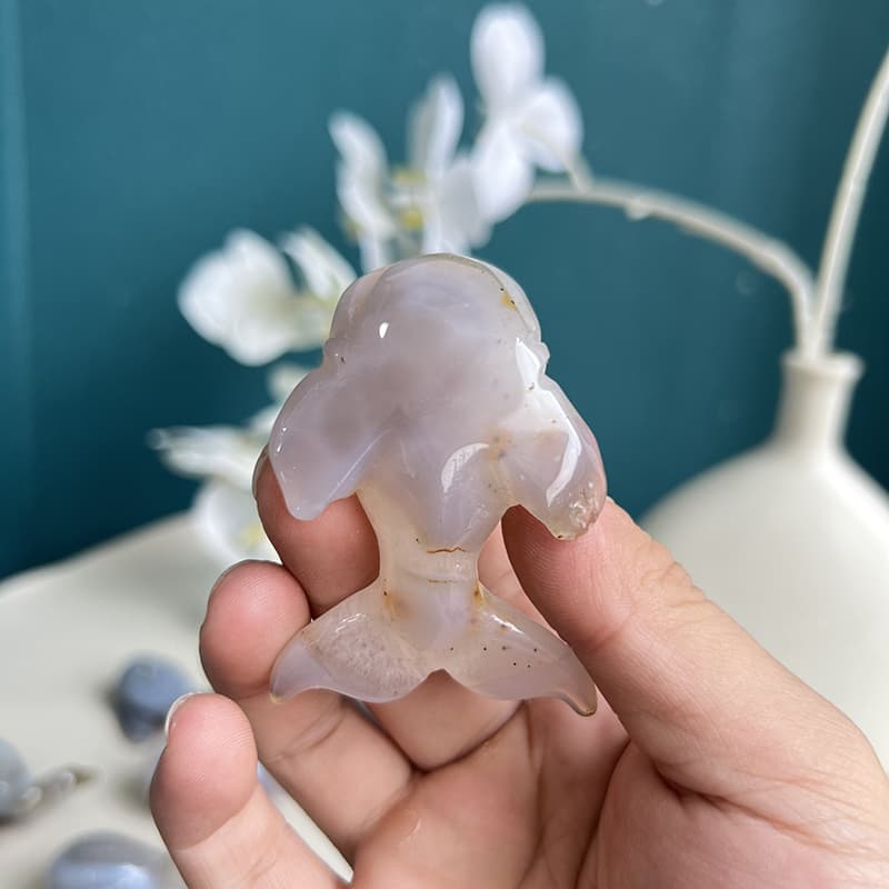 Dolphin agate crystal carving held in palm showing size proportion