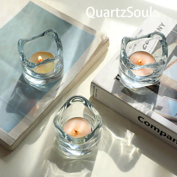 Crystal clear glass candle holder with wavy organic design and lit tealight candle