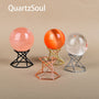 Crystal spheres displayed on geometric metal stands in various finishes