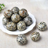 Dalmatian Jasper polished tumbled stones in various sizes on white plate