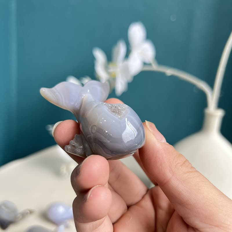 Close-up of dolphin agate crystal tail detail showcasing fine carving work and natural crystal formations
