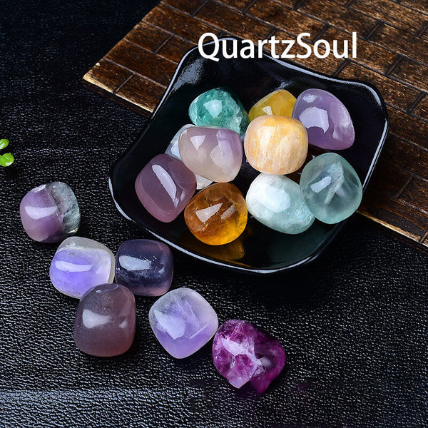 Assorted fluorite tumbled crystals in black display bowl showing vibrant colors