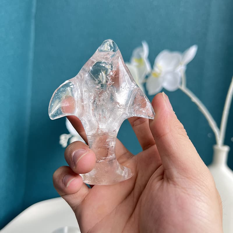 Side profile of hand-carved flying fish crystal showing delicate fin details