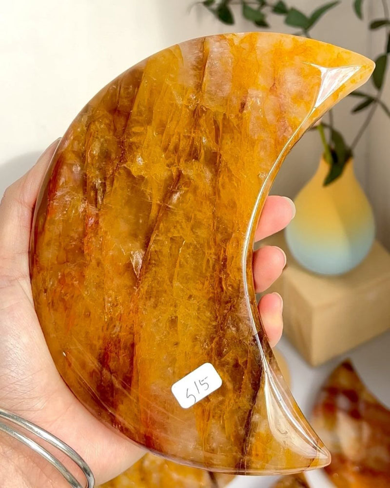 Golden Healer Moon Crystal displayed on wooden stand showing healing properties