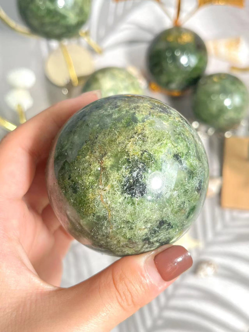 Green Apidote Crystal Sphere being used in crystal healing session