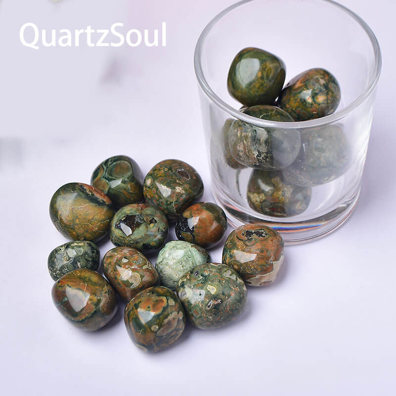 Natural Kambaba Jasper tumbled stones in glass container showing green and orbicular patterns