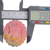 Digital caliper measuring width of pink Rhodonite crystal carving at 39.6mm