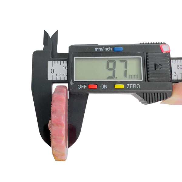Digital caliper showing thickness of Rhodonite crystal carving at 9.7mm