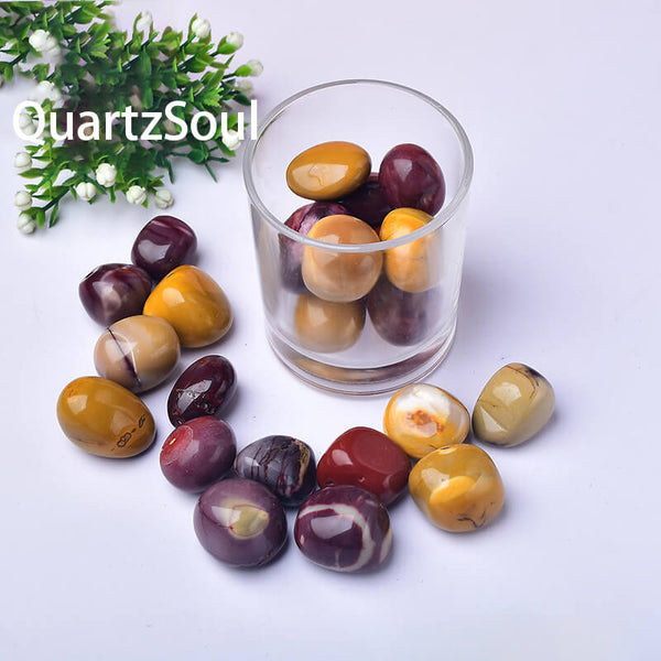 Natural Mookaite Jasper tumbled stones collection in glass container showing burgundy and golden colors