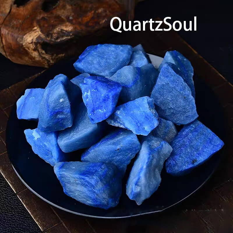 Natural raw Blue Aventurine crystal chunks displayed on black plate with vibrant blue color