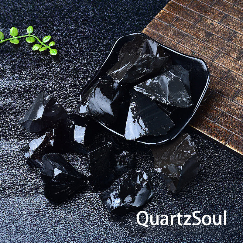 Natural raw obsidian crystal volcanic glass with glossy black surface