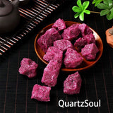 Natural raw red corundum crystals in a wooden bowl with tea ceremony setting