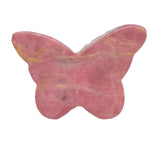 Natural rhodonite butterfly carving as part of crystal collection display