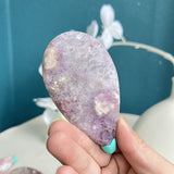 Close-up detail of pink amethyst crystal structure in whale carving