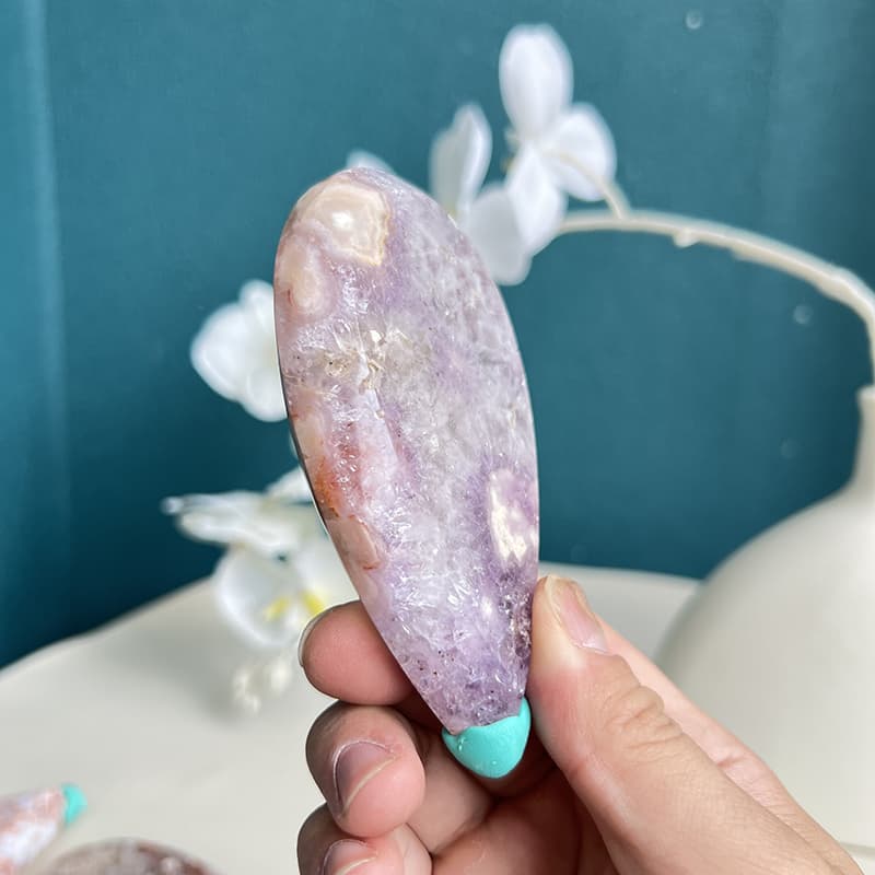 Pink amethyst whale crystal carving displayed on wooden stand