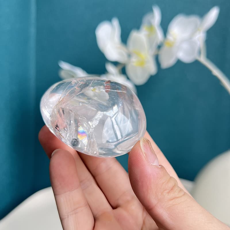 Clear quartz free form crystal being held to show size and transparency