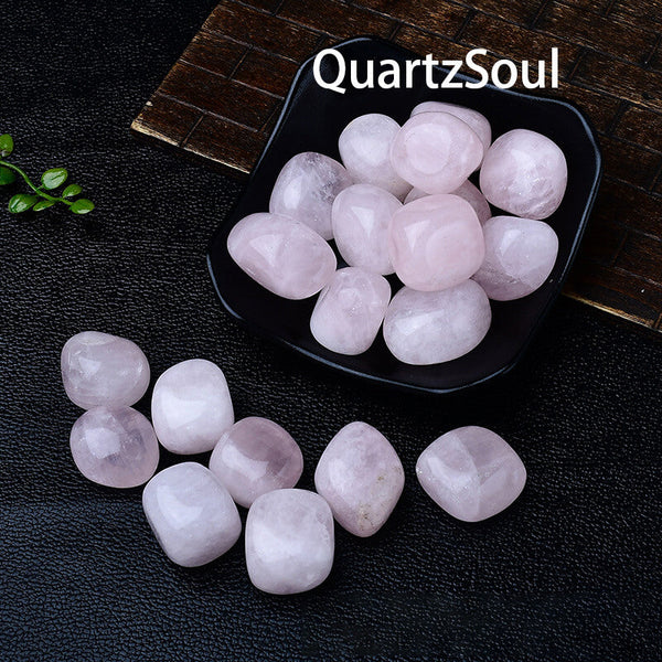 Premium quality rose quartz tumbled stones displayed in black bowl showing 2-3cm size and translucent pink hue
