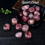 Natural Purple Aventurine tumbled stones in black display bowl with green plant accent