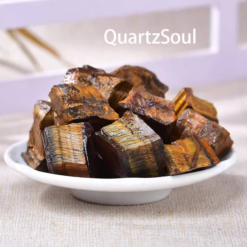 Collection of raw Tiger's Eye crystals in a dish showcasing natural golden sheen and protective properties