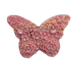 Light reflection on polished rhodonite butterfly crystal carving