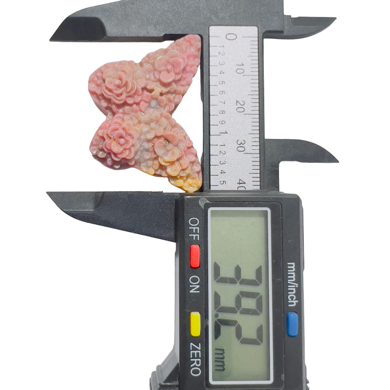Side profile of handcrafted rhodonite butterfly crystal showing natural stone texture