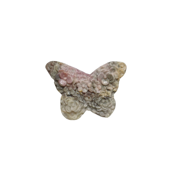 Rhodonite butterfly carving held in palm showing size perspective