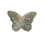 Close-up of rhodonite butterfly carving showing detailed flower patterns