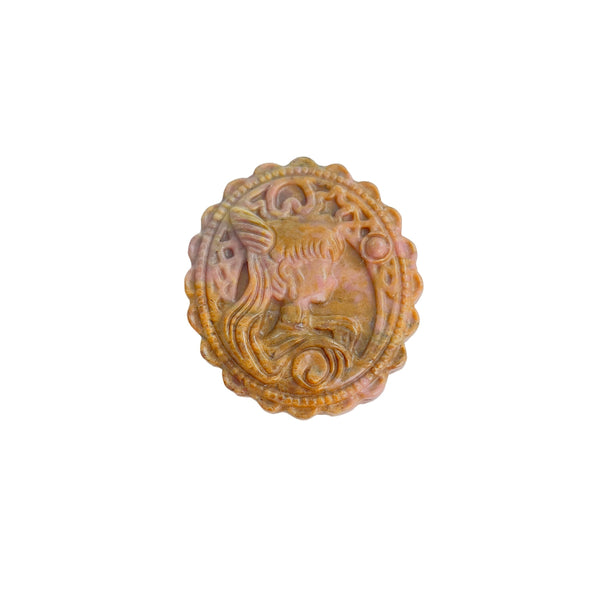 Magical girl rhodonite crystal carving displayed with complementary healing stones