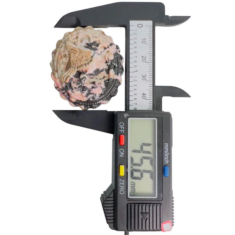 Rhodonite crystal held in palm showing size and vibrant pink coloration