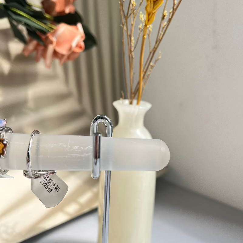 Selenite crystal ring holder shown at angle with jewelry