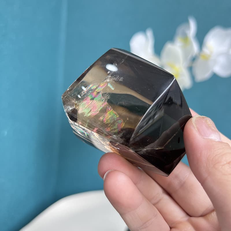 Smoky quartz free form crystal displayed with white orchids