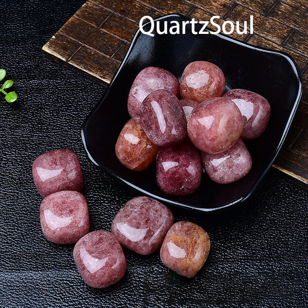 Natural strawberry quartz tumbled stones displayed in black bowl, pink polished crystals