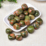 Collection of polished Unakite tumbled gemstones in white dish for crystal healing