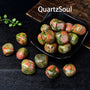 Premium unakite tumbled gemstones in black display bowl showing vibrant color variation