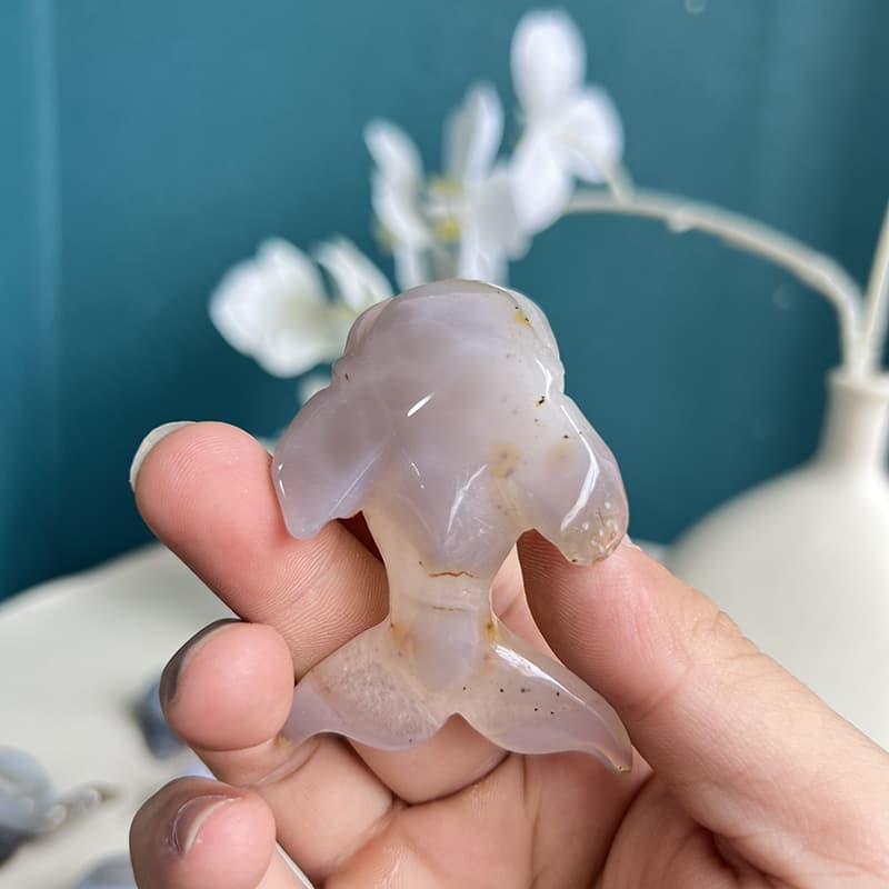 White agate crystal dolphin carving viewed from side angle