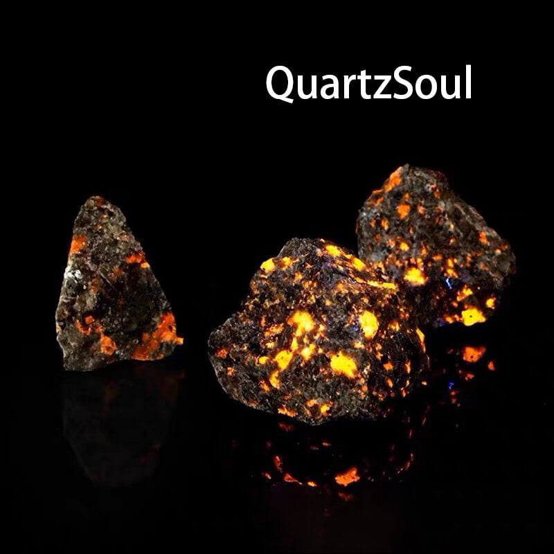 Collection of natural Yooperlite raw stones showing size variation and fluorescent mineral properties
