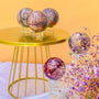 Premium Moonkaite Crystal Spheres on Gold Display Stand with Purple Flowers