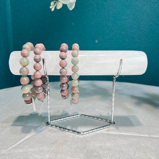 Natural Clear Quartz crystal bracelet holder with multi-colored beaded bracelets on display