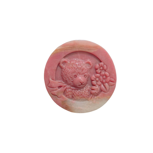 Side angle of rhodonite bear carving displaying natural stone patterns